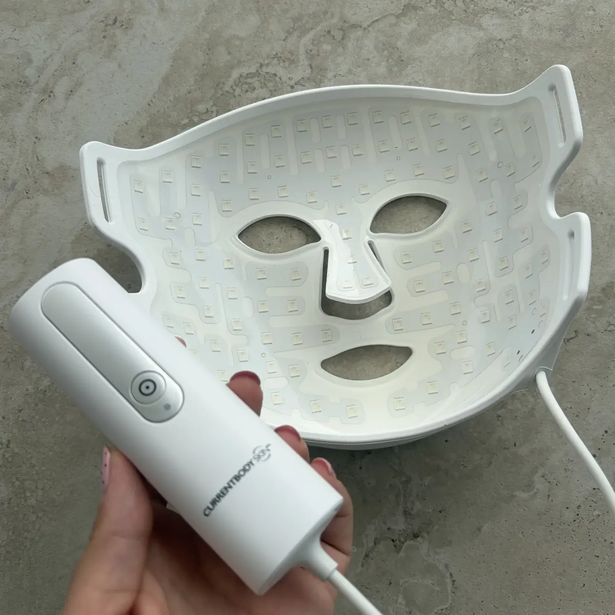 The CurrentBody Series 2 external battery pack next to the folded silicone mask