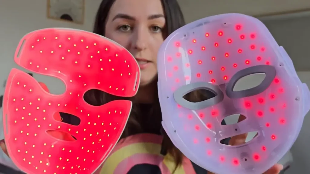 Emilie holding two lit LED masks side by side, the left one packed with closely spaced diodes, the right one with visible gaps between them