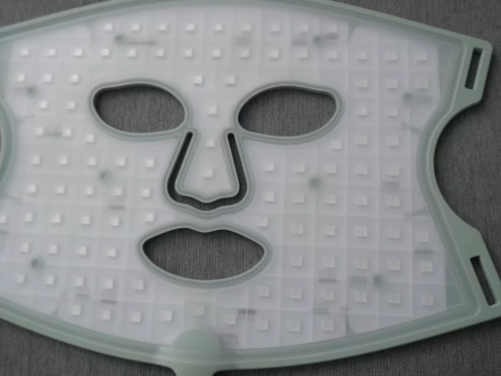 Unlit Nanoleaf LED mask laid flat, showing square emitter pads spread across a completely flat silicone sheet