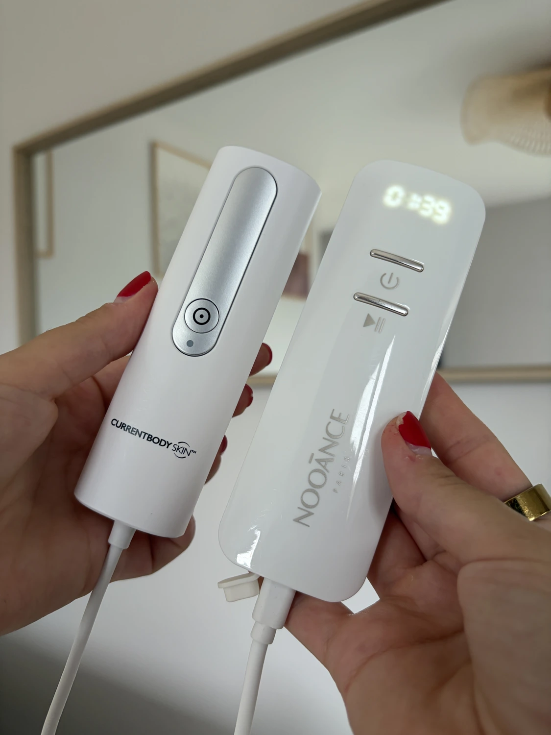 The two remotes side by side: the CurrentBody Series 2 controller with a single button, and the Nooance Elite X600 remote with a lit countdown display and two buttons