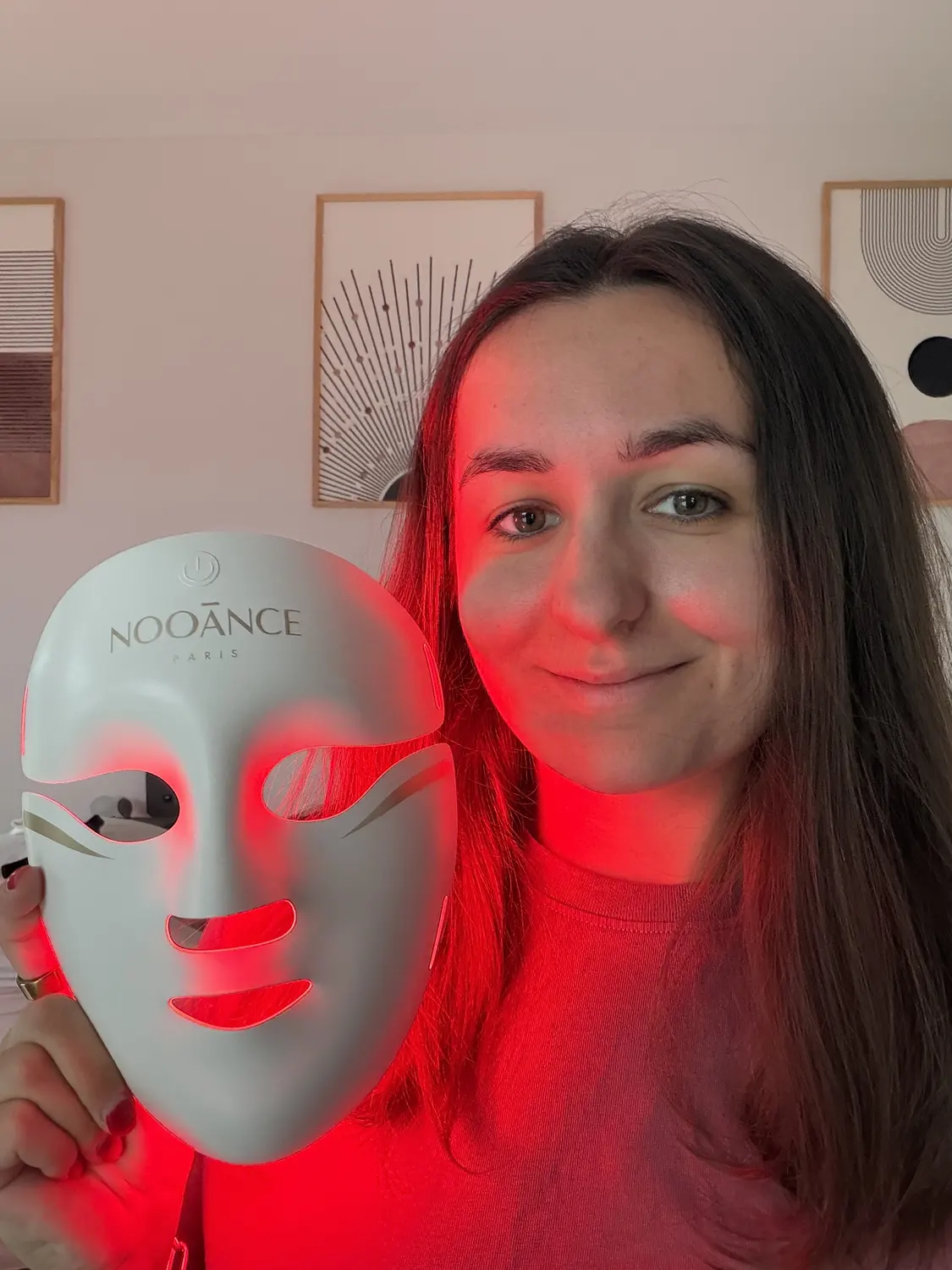 Emilie holding the white Nooance Aurion X252 LED mask next to her face, device switched off