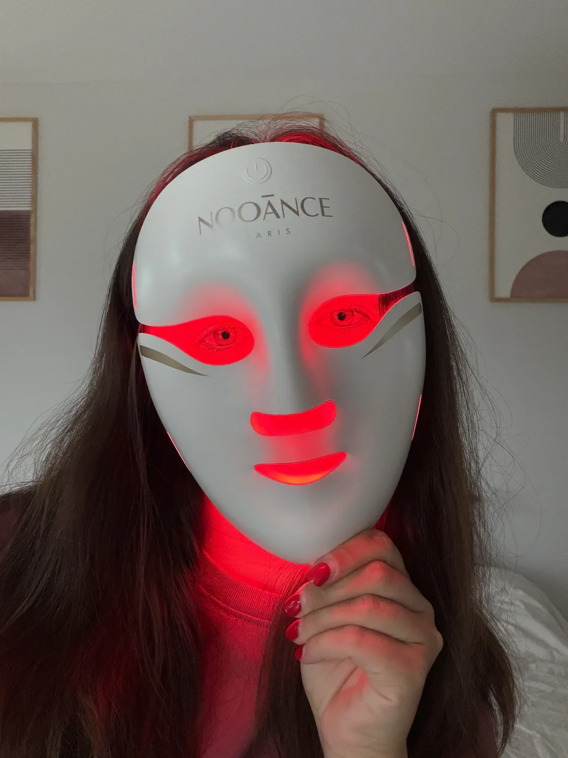 Emilie wearing the white Aurion X252 LED mask, red light showing through the eye and mouth cutouts
