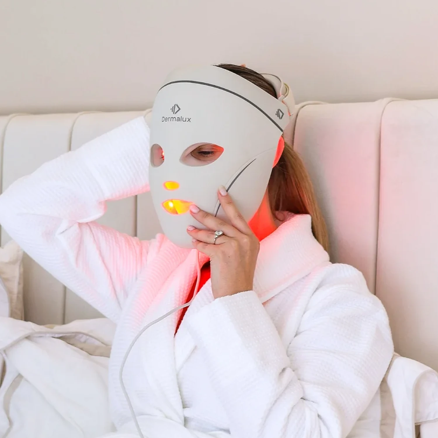 Woman wearing the Dermalux LED Face Mask, eye open behind the moulded guard